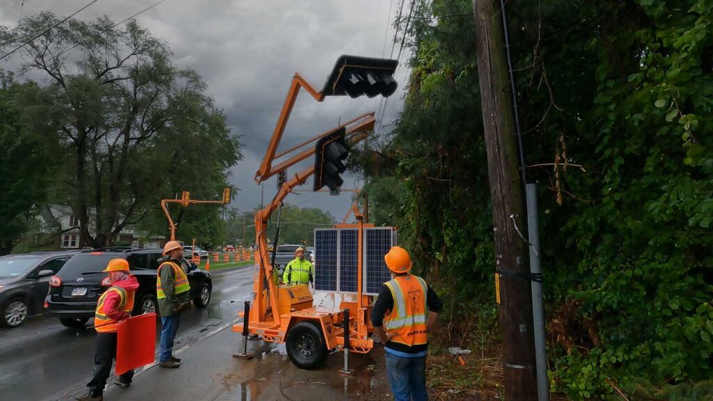 Portable traffic signal used in pilot car operations work zone with crew on site